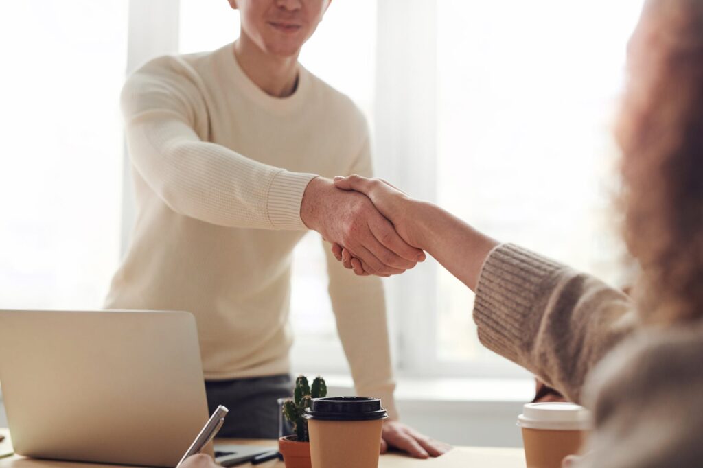 man and woman handshake near table