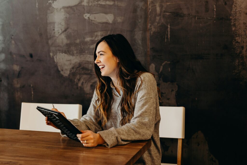 woman-sitting-around-table-holding-tablet